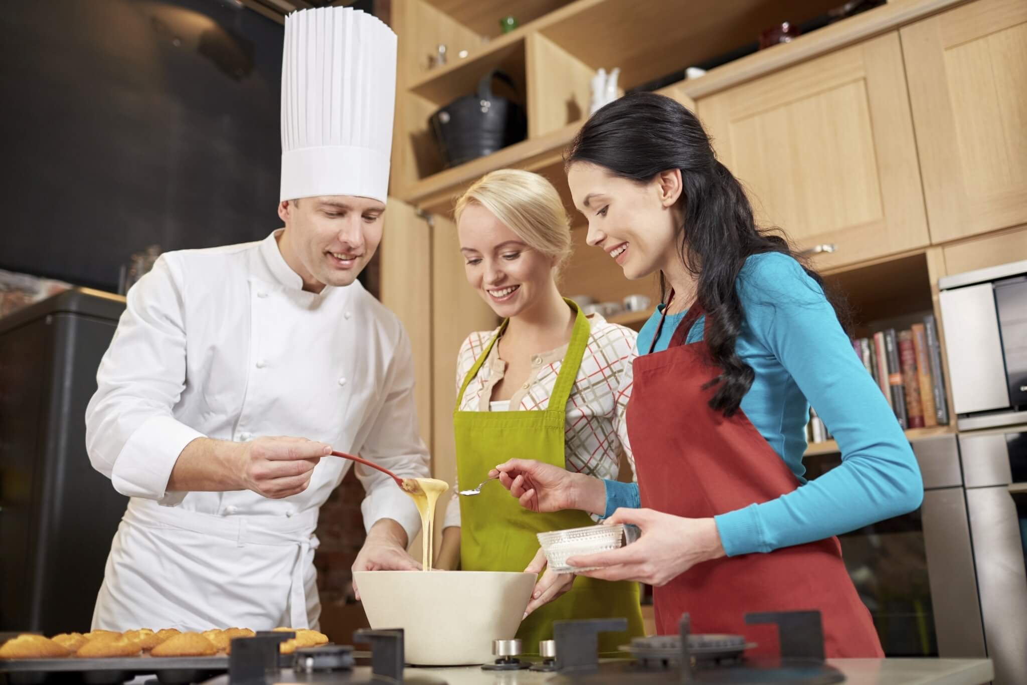 Happy women and chef cook baking in kitchen 000070772171 Full jpg